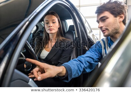 ストックフォト: Woman Looking At Mechanic Checking Light Switch Of Car