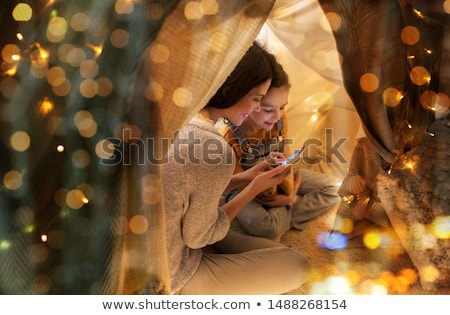 Foto stock: Happy Family With Smartphone In Kids Tent At Home