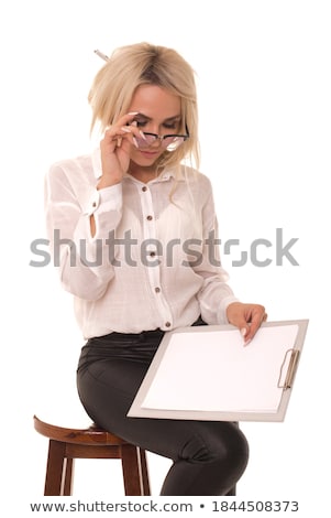 Stockfoto: Young Businesswoman Sitting On A Chair And Holding Tablet In Her