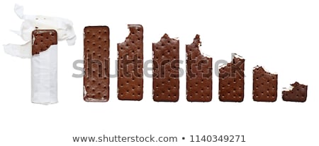 Stok fotoğraf: Chocolate Bar With A Missing Bite In The Wrapper Over White