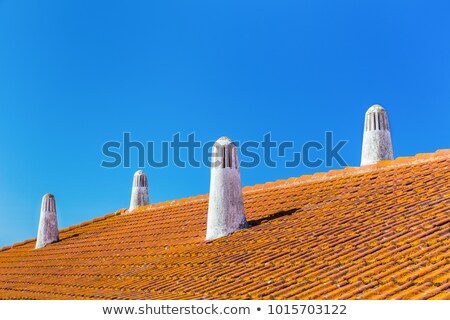 Foto stock: Orange Roof Tiles With Four White Chimneys