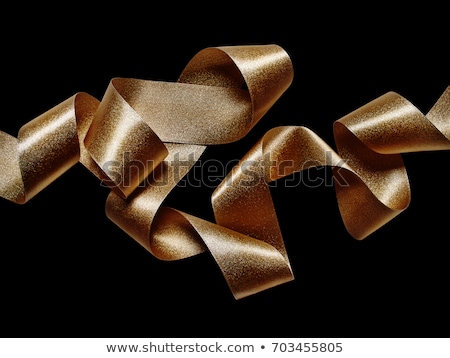 Foto d'archivio: Gold Serpentine Metallic Ribbons On Black Background