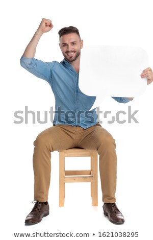 Foto stock: Seated Young Man Holding Talk Bubble Up In The Air