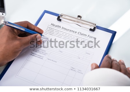 Foto stock: Disabled Patient Filling Insurance Claim Form