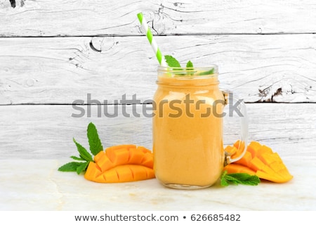 Stock photo: Mango Smoothie In A Glass Mason Jar And Mango On The Old Wooden Background Mango Shake