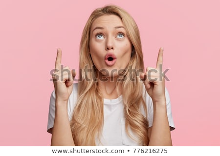 Foto stock: Young Beautiful Woman Pointing Up On Copy Space In Surprise