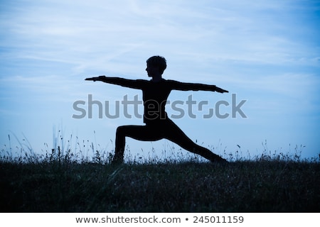 ストックフォト: Silhouette Of Woman Practicing Yoga With Raised Arms On The Sunset