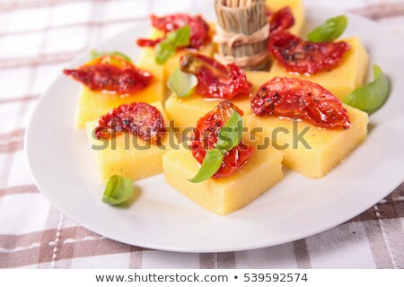 Foto stock: Appetizerpolenta With Dry Tomato And Basil