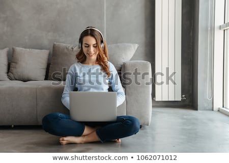 Stock foto: Woman Using Laptop While Listening Music On Headphones