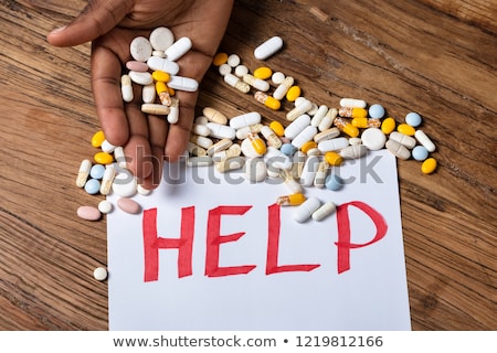 Stock photo: Man Holding Pills With Help Text On Paper