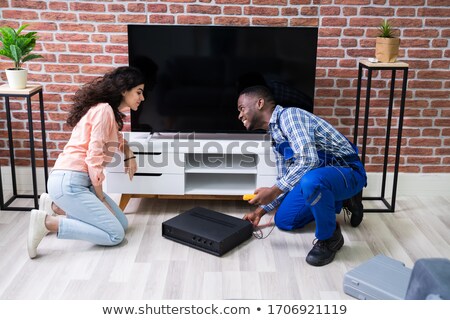 Stock photo: Woman Sitting Near Technician Repairing Amplifier