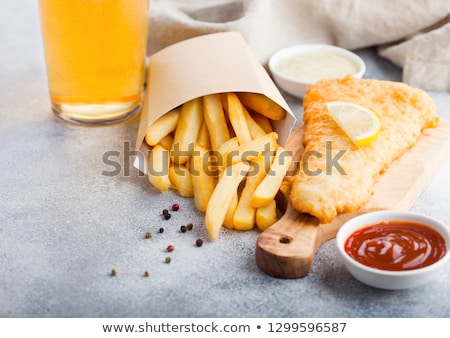 [[stock_photo]]: Traditional British Fish And Chips With Tartar Sauce Abd Glass Of Craft Lager Beer On Chopping Board