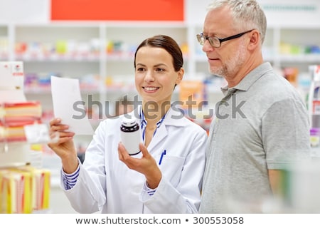 Stok fotoğraf: Senior Apothecary With Prescription At Pharmacy