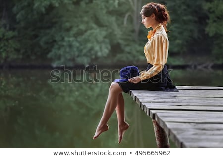 Stock photo: Young Woman Sitting On The Pier On The Lake