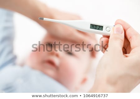 ストックフォト: Medical Thermometer In Hand Of Pediatrician On Background Of Sick Little Girl