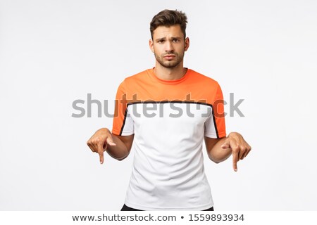 ストックフォト: Disappointed Gloomy Cute Masculine Man With Bristle Wear Sports T Shirt Pointing Down Frowning A