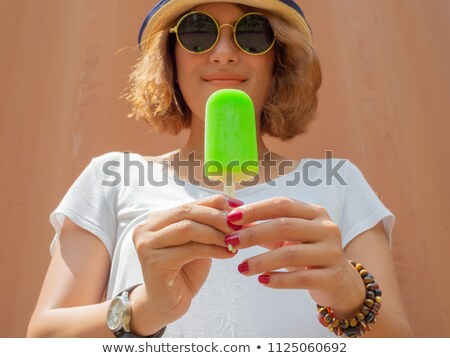 Zdjęcia stock: Happy Woman In Round Sunglasses Eating Lollipop Outdoors