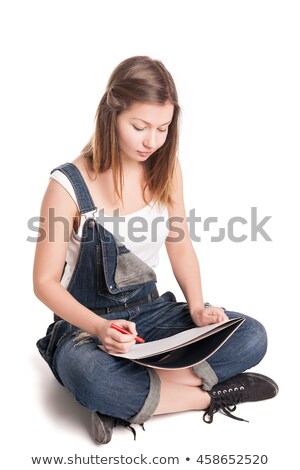 Foto stock: Young Woman Happily Sitting Cross Legged On The Floor Drawing In Her Note Pad