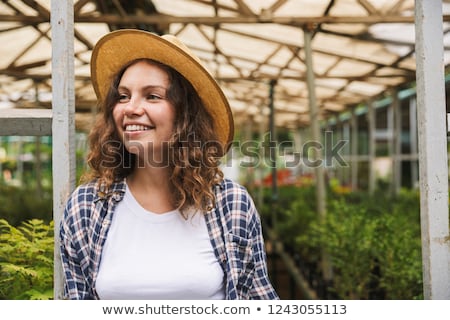 Foto stock: Florist Woman 20s Working In Greenhouse Over Plants