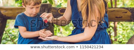 [[stock_photo]]: Mother And Son Using Wash Hand Sanitizer Gel In The Park Before A Snack Banner Long Format
