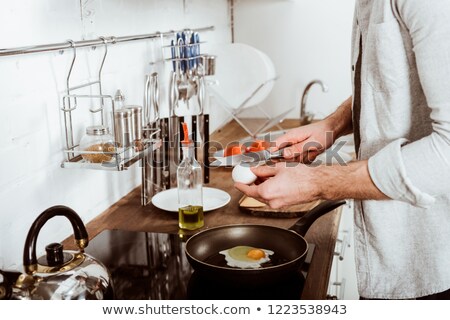 Stockfoto: Cropped Image Of Man Cooking Scrambled Eggs On Frying Pan