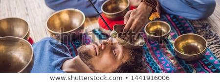 Stok fotoğraf: Banner Long Format Nepal Buddha Copper Singing Bowl At Spa Salon Young Beautiful Man Doing Massage