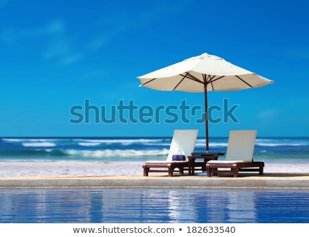 Stok fotoğraf: Two Chairs With White Umbrella Near The Beach