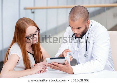 Stock foto: Two Attractive Young Doctors Looking At X Ray Results