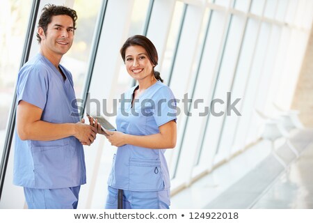 Foto stock: Os · enfermeras · de · pie · en · un · pasillo · del · hospital