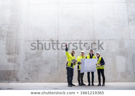 Сток-фото: Architect Standing In An Empty Space And Holding A Plan