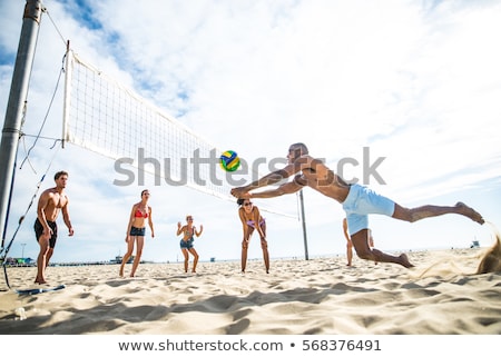 [[stock_photo]]: Friends Outdoors On The Beach Play Volleyball Having Fun