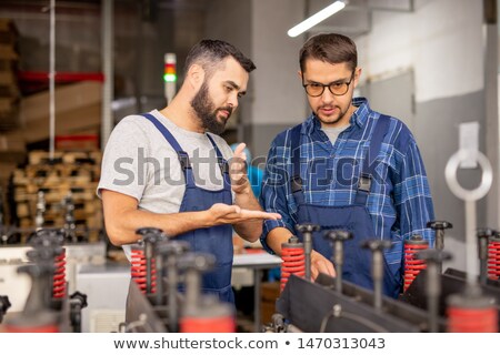 Foto stock: Professional Machinery Engineer Giving Instructions To His Trainee