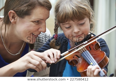 Foto stock: Teacher Helping Young Female Pupil In Violin Lesson