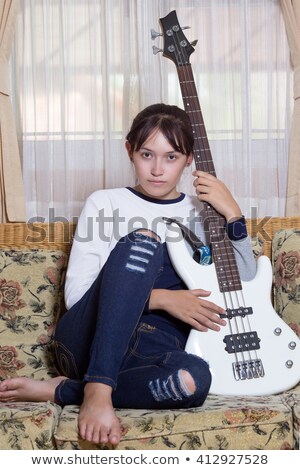 Imagine de stoc: Beautiful Bass Player Sitting With Her Guitar