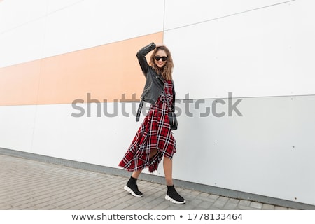 A Young Woman In Casual Clothes And Sunglasses Walks Near The Building Stok fotoğraf © Alones