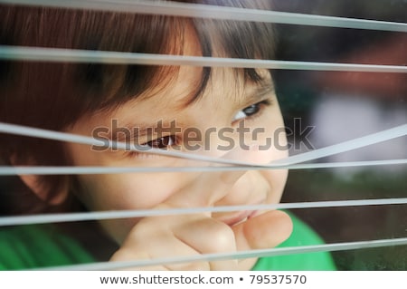Portrait Of An Innocent Small Boy Peeping Through Window With Jalousie Foto stock © Zurijeta