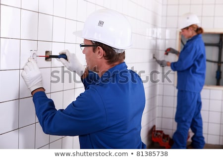 Foto stock: Two Electricians Working In Public Rest Room