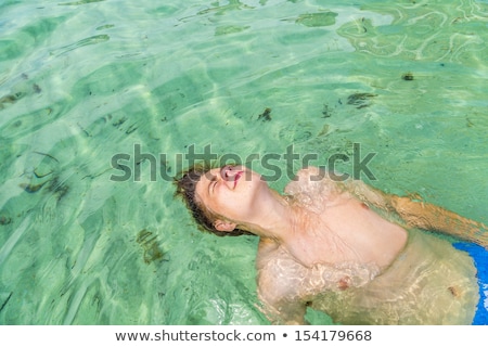 Stock fotó: Handsome Teen Has Fun Playing Dead Mens Float In The Ocean