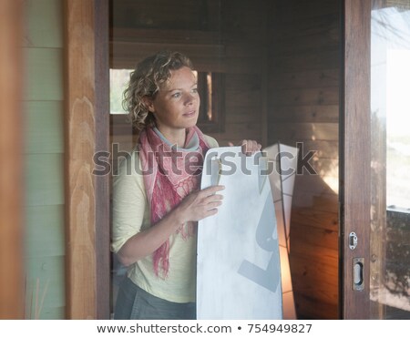 Stockfoto: Woman In A Beach House Holding Kiteboard