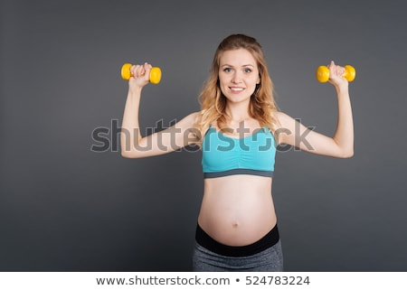 Сток-фото: Attractive Pregnant Woman Using A Dumbbell While Training