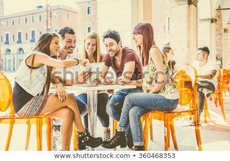 Stockfoto: Cheerful Woman Reading Ebook At Cafe