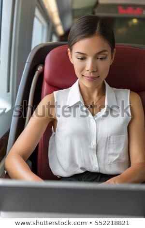 Young Chinese Businesswoman Working Writing Emails On Computer While Commuting To Work In The Mornin Stockfoto © Maridav