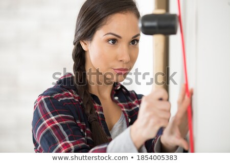 Сток-фото: Attractive Woman On Ladder With Hammer