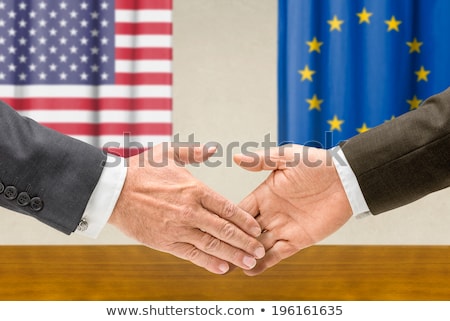 Foto stock: Representatives Of The Usa And The Eu Shake Hands