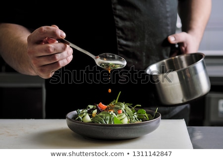 Stok fotoğraf: Chef Plating Up Food In A Restaurant
