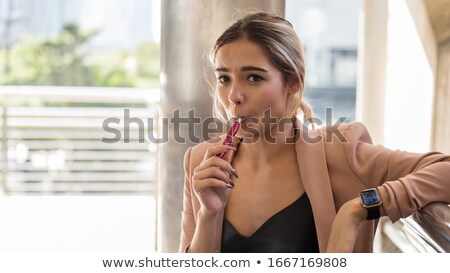 Foto stock: Beautiful Woman In The Sunset Holding E Cigarette