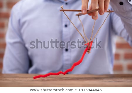 Stock fotó: Persons Hand Manipulating Blue Arrow With Rope