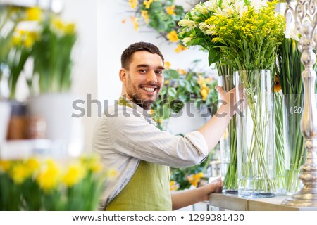 Сток-фото: Happy Florist Man Setting Flowers At Flower Shop