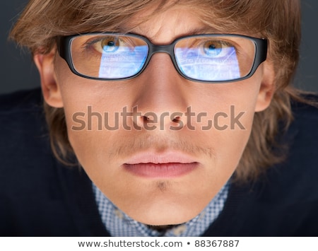 Foto stock: Satisfied Young Man With Glasses Looking At Camera Like At Lapto