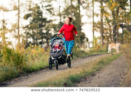 Stockfoto: Mother With Stroller Enjoying Motherhood At Sunset Landscape